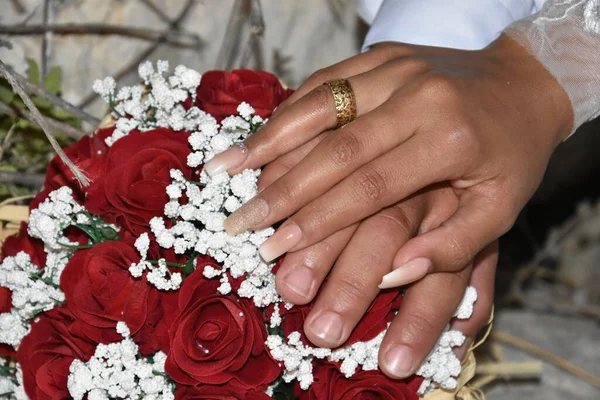 Händer Nygifta Med Guld Vigselringar Bröllopsbukett Röda Och Vita Blommor — Stockfoto