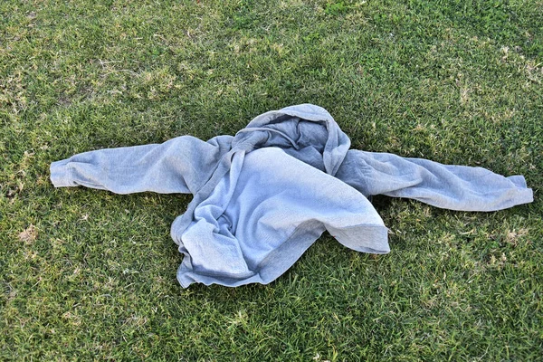 灰色毛衣 袖子很长 躺在青绿新鲜的草地上 高质量的照片 — 图库照片