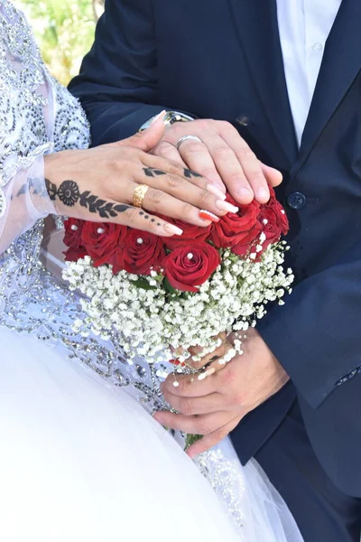 Händer Nygifta Med Bröllop Guld Ringar Och Brudbukett Röda Ros — Stockfoto