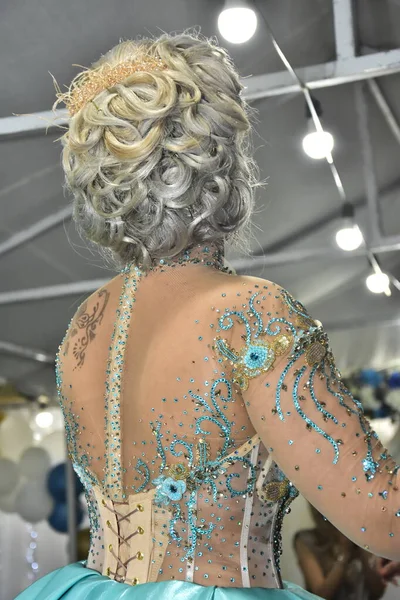 Наречена в бірюзовій весільній сукні, з зачіскою з довгим фарбованим волоссям, стоїть зі спиною, весілля — стокове фото
