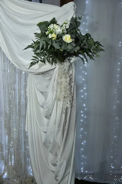 Cortina blanca para la decoración de las vacaciones de boda y flores de rosas blancas con hojas verdes — Foto de Stock