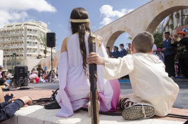 Beer-Sheva, İsrail-5 Mart, 2015:Girl ve çocuk beyaz elbiseli - seyirci manzaraları - Purim otur