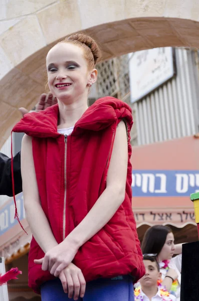 Beer-Sheva, ISRAEL - March 5, 2015: Girl gymnast with red hair in a red jacket without sleeves -Purim — Stock Photo, Image