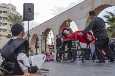 Beer-Sheva, İsrail-5 Mart 2015: Yahudi genç çocuk dışında oturan ve bir sihirbaz performans - Purim izlerken siyah ve siyah yığın