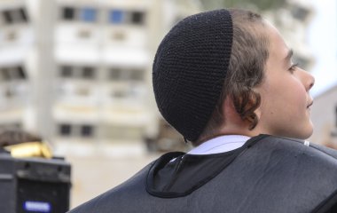 Beer-Sheva, İsrail-5 Mart 2015: Yahudi genç çocuk siyah ve siyah yığın açık havada - oturma portre profil-Purim