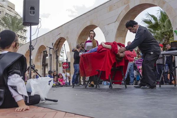 Beer-Sheva, ISRAEL - March 5, 2015: Jewish teenage boy in black and black pile sitting outside and watching a magician performance — Stock Photo, Image