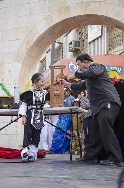 Beer-Sheva, ISRAEL - 5 mars 2015 : Garçon juif en costume noir et pile noire sur scène avec magicien - Pourim — Photo