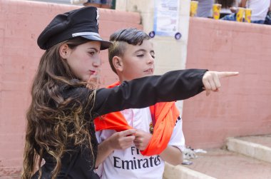 Beer-Sheva, İsrail-5 Mart, 2015:Girl profil teen boys ile ayakta siyah polis şapkalı güzel uzun saçlı-Purim