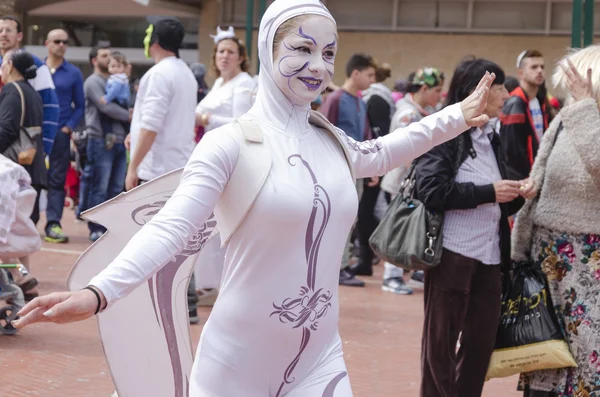 Beer-Sheva, ISRAEL - 5 de marzo de 2015: Muchacha de blanco con alas de ángel y maquillaje blanco en la cara se para entre la multitud - Purim — Foto de Stock