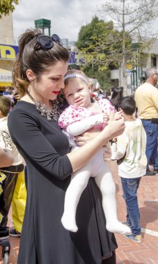 Beer-Sheva, İsrail-5 Mart 2015: Genç anne kalabalıkta kucağında bir bebekle-Purim