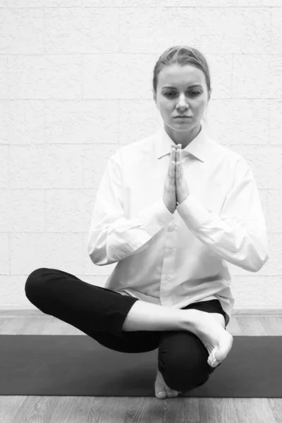  Yoga pozu veren katı takım elbiseli bir kızın siyah beyaz fotoğrafı. - Sanat. Dergi için fotoğraf..