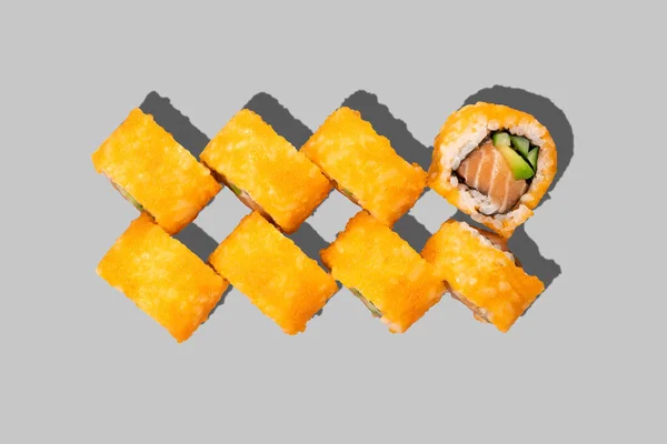 灰色の背景に隔離された寿司巻き アボカドとサーモンロール キャビアとキュウリ 日本食 レストランメニュー 上のビュー — ストック写真