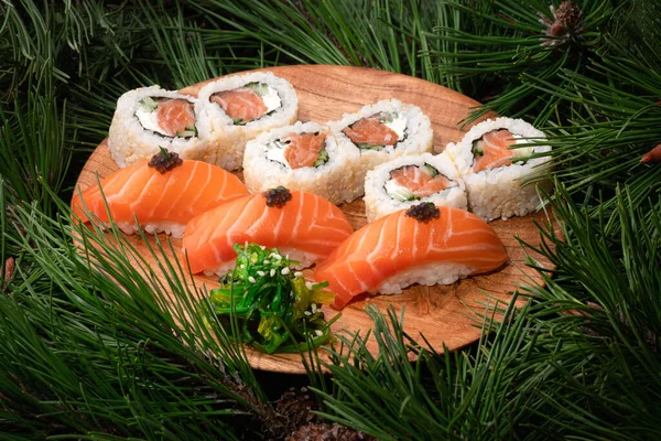 Zestaw Sushi Drewnianej Płycie Gałązkami Jodły Tle Stół Świąteczny Noworoczny — Zdjęcie stockowe