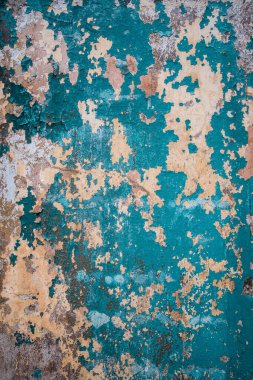 Mavi boyalı, eski renkli duvarın soyut grunge dokusu. Yaratıcı bir geçmiş. Yeşil, gri, mavi ve turuncu eskimiş taş desenli, sıva ve boyalı. Dikey, boşluğu kopyala