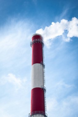 Mavi gökyüzüne karşı endüstriyel boru. Bacadan duman çıkıyor. Hava kirliliği. Enerji için yanan atıklar. Yakma fabrikası. Alternatif enerji çöplüğü. Dikey, kapat, boşluğu kopyala