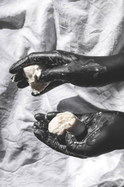 Beyaz arka planda ellerini yıkıyor. Yaratıcı stil el yıkama. Siyah lateks eldivenli beyaz sabunlu bir kadın. Kişisel bakım, hijyen, temizlik, spa, banyo ve güzellik ürünleri konsepti. Doğal el sabunu.