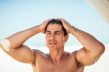 Kumsalda duş alıyor