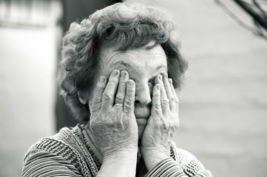 Yaşlı kadın yüzünü kaplayan