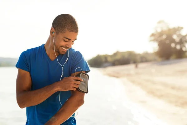 Choosing his favorite workout music — Stock Photo, Image