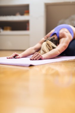 Evde yoga yapıyor