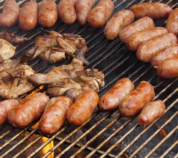 Barbecued meat and pork sausages on grill — Stock Photo, Image