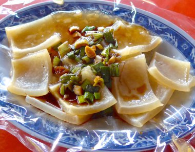 Sos ve doğranmış yeşil soğan ile haşlanmış domuz derisi