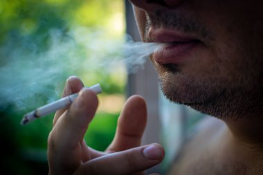 Sakallı adam bir sigara içiyor. Sigara öldürür..