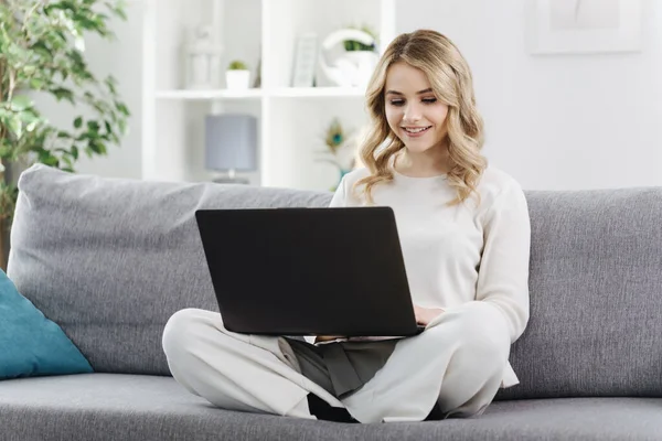 Evde dizüstü bilgisayarda internette sörf yapan bir kadın. — Stok fotoğraf
