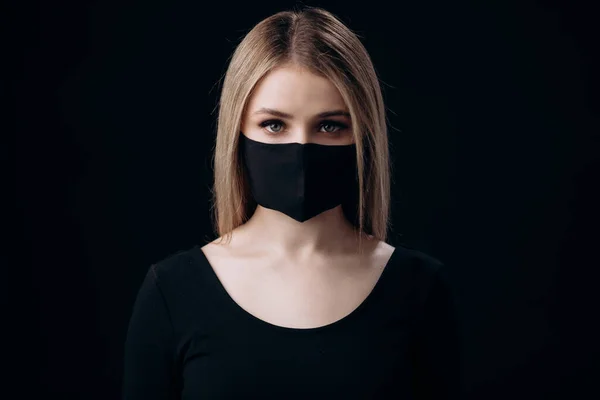 Mujer en máscara médica sobre fondo negro — Foto de Stock