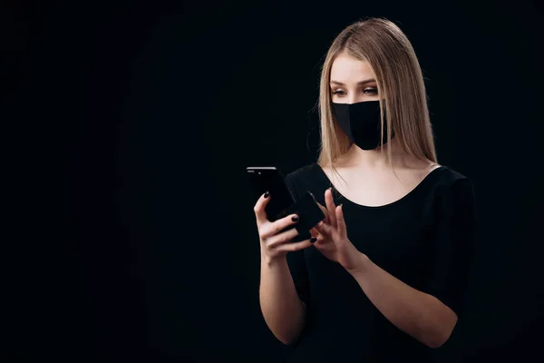 Mujer con máscara con tarjeta de crédito y teléfono inteligente — Foto de Stock