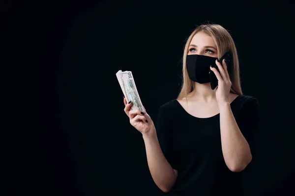 Maskierte Frau hält Bargeld in der Hand und telefoniert mit Handy — Stockfoto