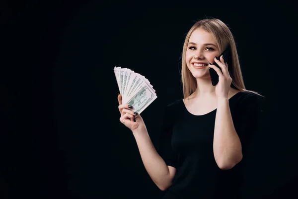 Kvinna med pengar kontanter som har mobil prata — Stockfoto