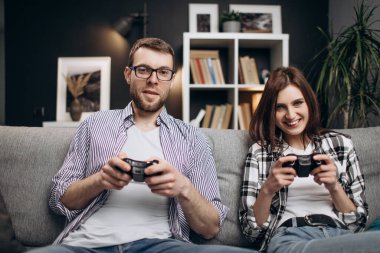 Oyun oynamak için joystickleri kullanan genç çift
