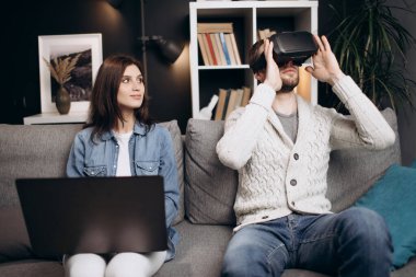 Erkek ve kadın VR kulaklık ve dizüstü bilgisayar kullanıyor.