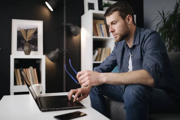 Homem trabalhando em laptop em uma casa — Fotografia de Stock