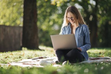 Mutlu kadın temiz hava için dizüstü bilgisayar kullanıyor.