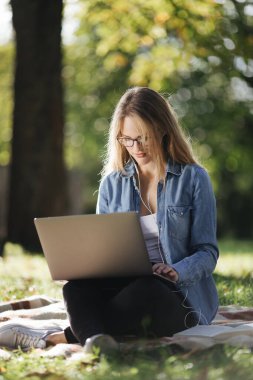 Dışarıda dizüstü bilgisayarda çalışan bir kadını etkilemek.