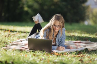 Green Park 'ta dizüstü bilgisayar kullanan bir kız öğrenci.