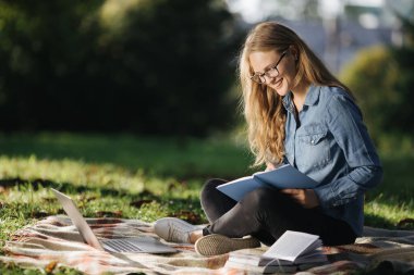 Sunny Park 'ta dizüstü bilgisayarlı güzel bir kadın oturuyor.