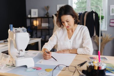 Kadın atölyede bir çizim yapıyor.