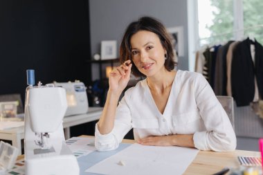 Kadın tasarımcı, bir kıyafet koleksiyonu çiziyor.