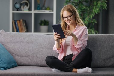 Kanepede tablet kullanan kadın.