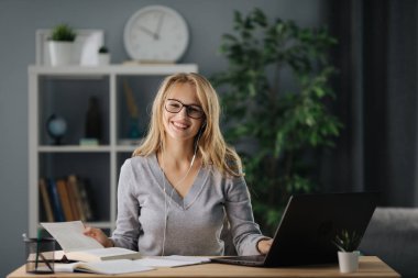 Mutlu sarışın evde ders çalışıyor.