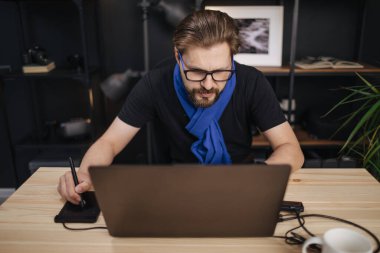 Fotoğrafçı bilgisayardaki fotoğrafları rötuşluyor