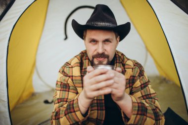 Gezgin çadırda poz veriyor.