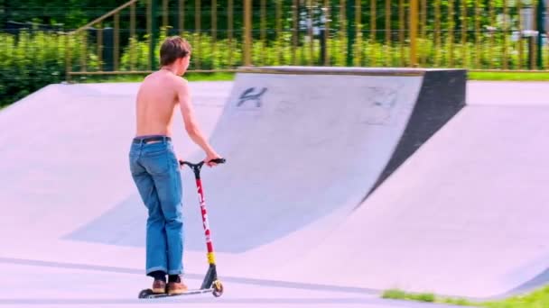 Rússia Moscou 2020. As crianças, os adolescentes montam skates e scooters no parque de rolos de rua de esportes radicais no outono. câmara lenta — Vídeo de Stock