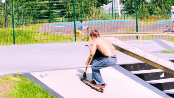 Russland Moskau 2020. Kinder, Jugendliche fahren im Herbst auf Skateboards und Rollern im Extremsport-Straßenroller-Park. Zeitlupe — Stockvideo