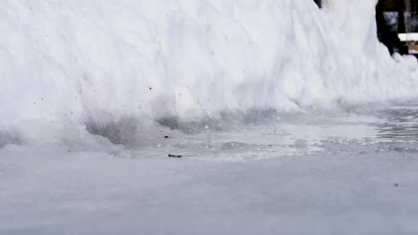 Close up shot of melting snow, water drops and bubbles in the small puddle in spring. During the shooting camera crashes on the ground. 25p — Stok video