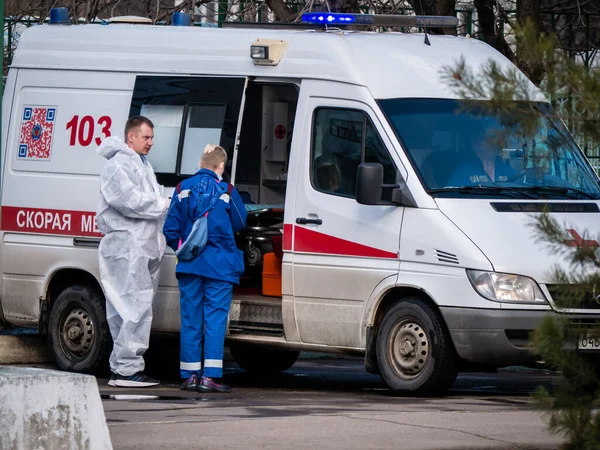 Rússia moscow 2021. Quatro médicos de ambulância conversando e de pé perto do carro Imagem De Stock