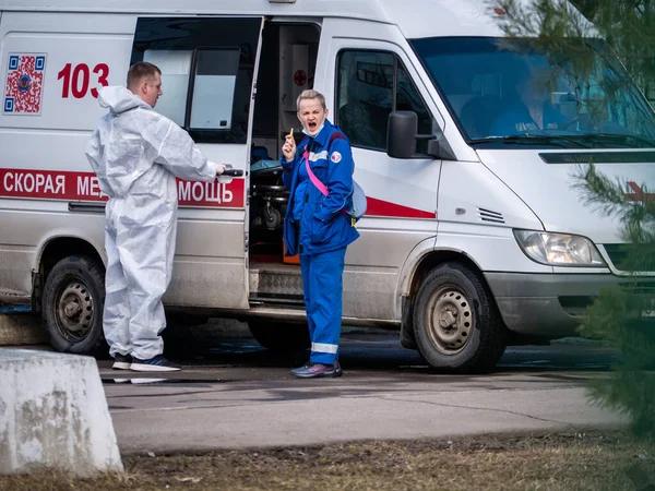 Rússia moscow 2021. Quatro médicos de ambulância conversando e de pé perto do carro Fotografia De Stock